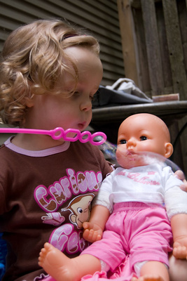 Showing her daughter (Clara) how to blow bubbles