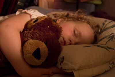 Fast asleep with her new bear friend