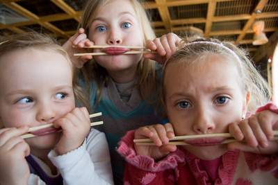 Veronika gets a chopsticks lesson from her visiting friends