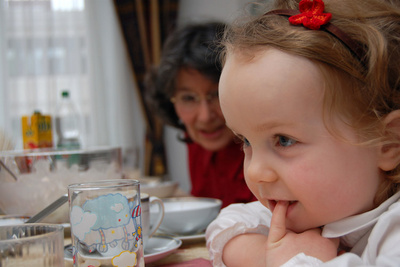 Anxiously watching her cousin Clara cut the birthday cake