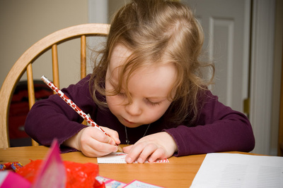 Diligently writing valentines to all her preschool friends